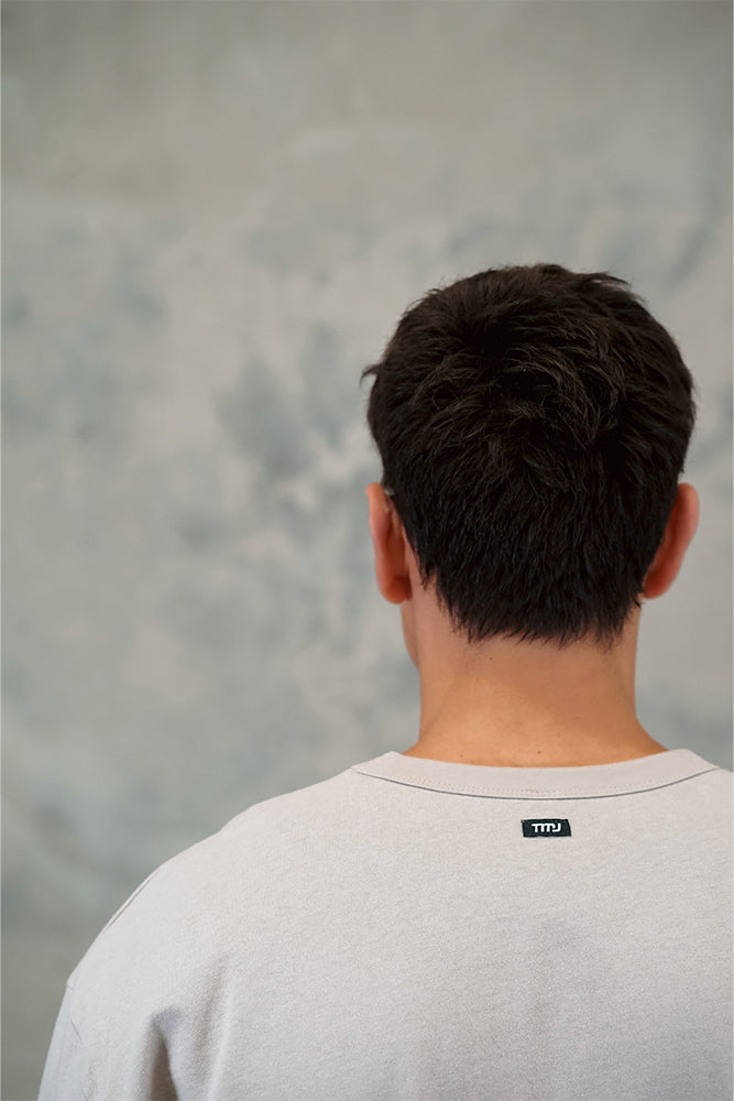  Male wearing TMJ Apparel 1993 Tee in Dune showing the small woven TMJ tag on back of collar.