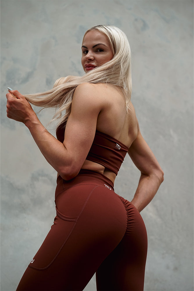 Female wearing TMJ Apparel Camilla Bandeau in Brown showing the back bandeau style. Pairing with Sculpt Tights V2 in Brown.