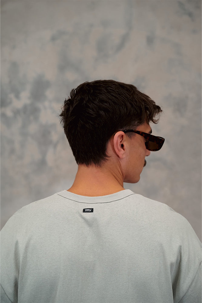  Male wearing TMJ Apparel 1993 Tee in Sage showing the small woven TMJ tag on back of collar