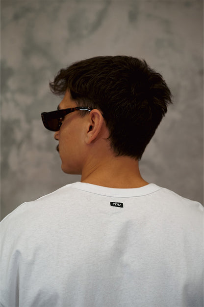  Male wearing TMJ Apparel 1993 Tee in Sage showing the small woven TMJ tag on back of collar