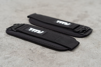Black TMJ Apparel Ankle Straps showing white rubber embossed &quot;TMJ&quot; logo sewn on the front.