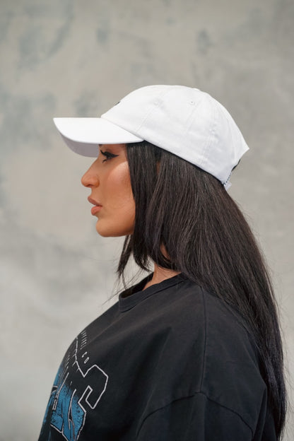 Female wearing black Chino Cap showing the side of cap.