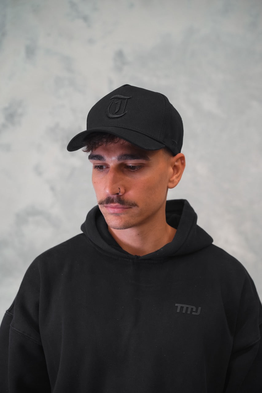 Male wearing Black TMJ Apparel 9PHIFTY A-Frame Snapback Hat with Black 3D Embroidered Magna Carta T Logo with black outline on the front.