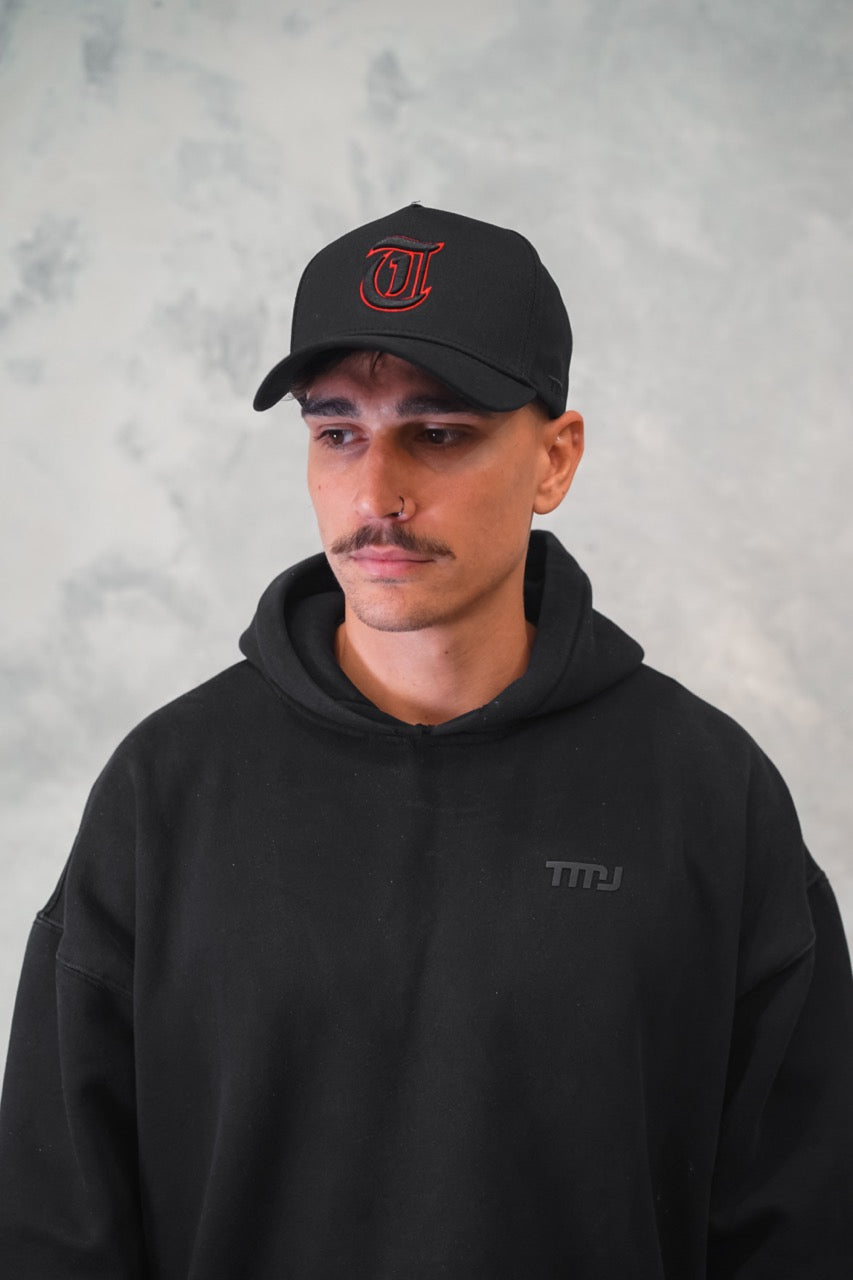 Male wearing Black TMJ Apparel 9PHIFTY A-Frame Snapback Hat with Black 3D Embroidered Magna Carta T Logo with red outline on the front.