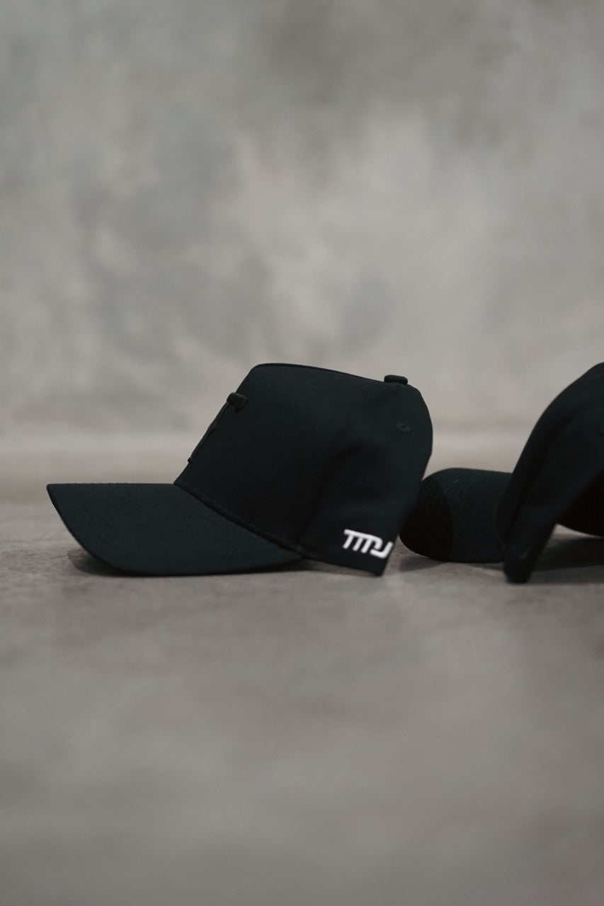 The side profiles of TMJ Apparel 9Phorty T A-Frame Snapback Hats in Black and Blackout