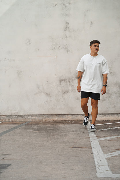 Male wearing TMJ Apparel Athleticulture Tee in Light Grey front of the shirt with white text saying TMJAPPARELCO Premium Athleticulture Goods on left of chest