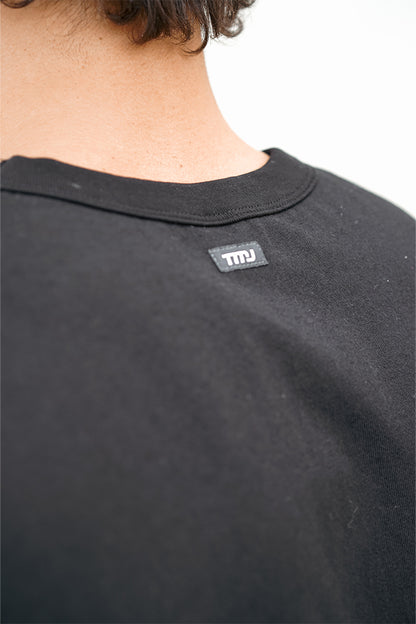 Male wearing TMJ Apparel Athleticulture Tee in Black showing the small TMJ tag on back of collar